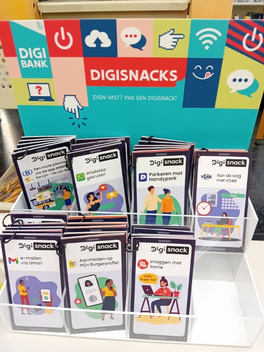 Display met DigiSnack boekjes over digitale vaardigheden zoals WhatsApp, Gmail, VDAB en inloggen met itsme. (vergroot foto)